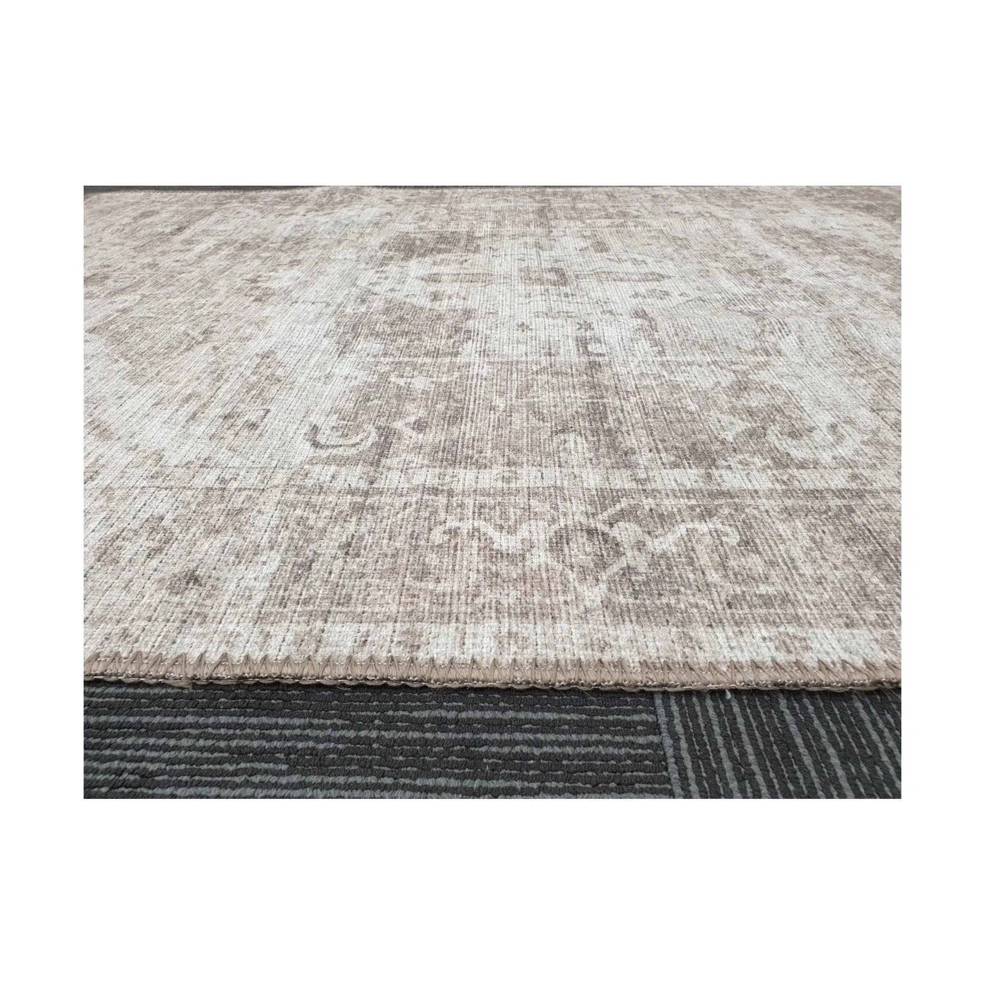 Low-angle close-up of ivory grey cotton rug edge and woven surface texture