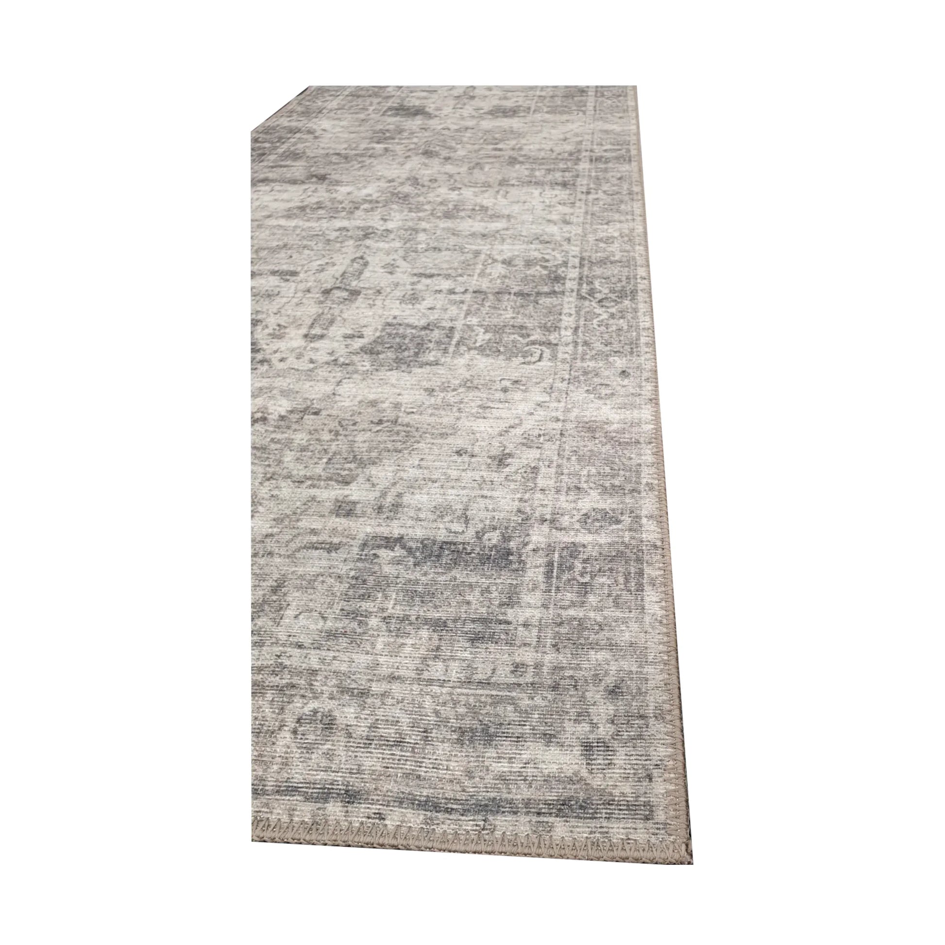 Close-up of ivory grey cotton runner rug corner with subtle ornamental edge detail