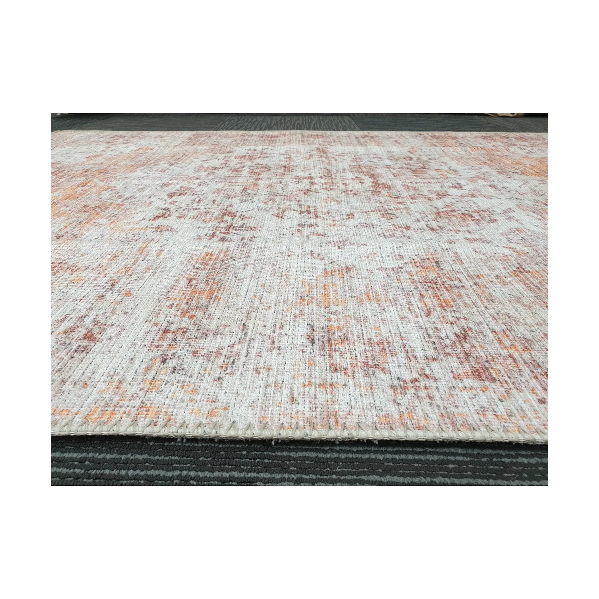 Low-angle close-up of ivory rust cotton rug edge and woven surface texture