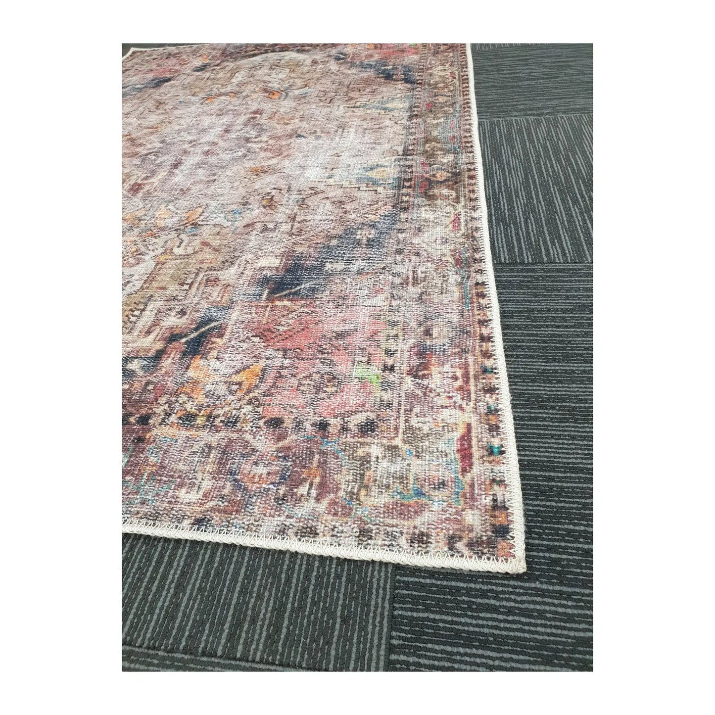 Close-up of ivory teal rust cotton rug corner with faded ornamental border detail