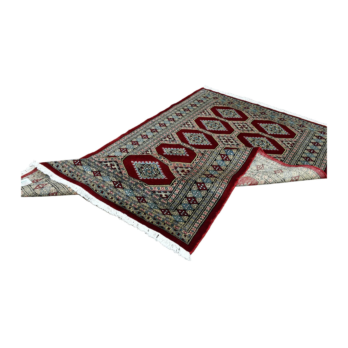Folded view of Jaldar hand-knotted wool rug showing its geometric field, layered borders and pale fringe