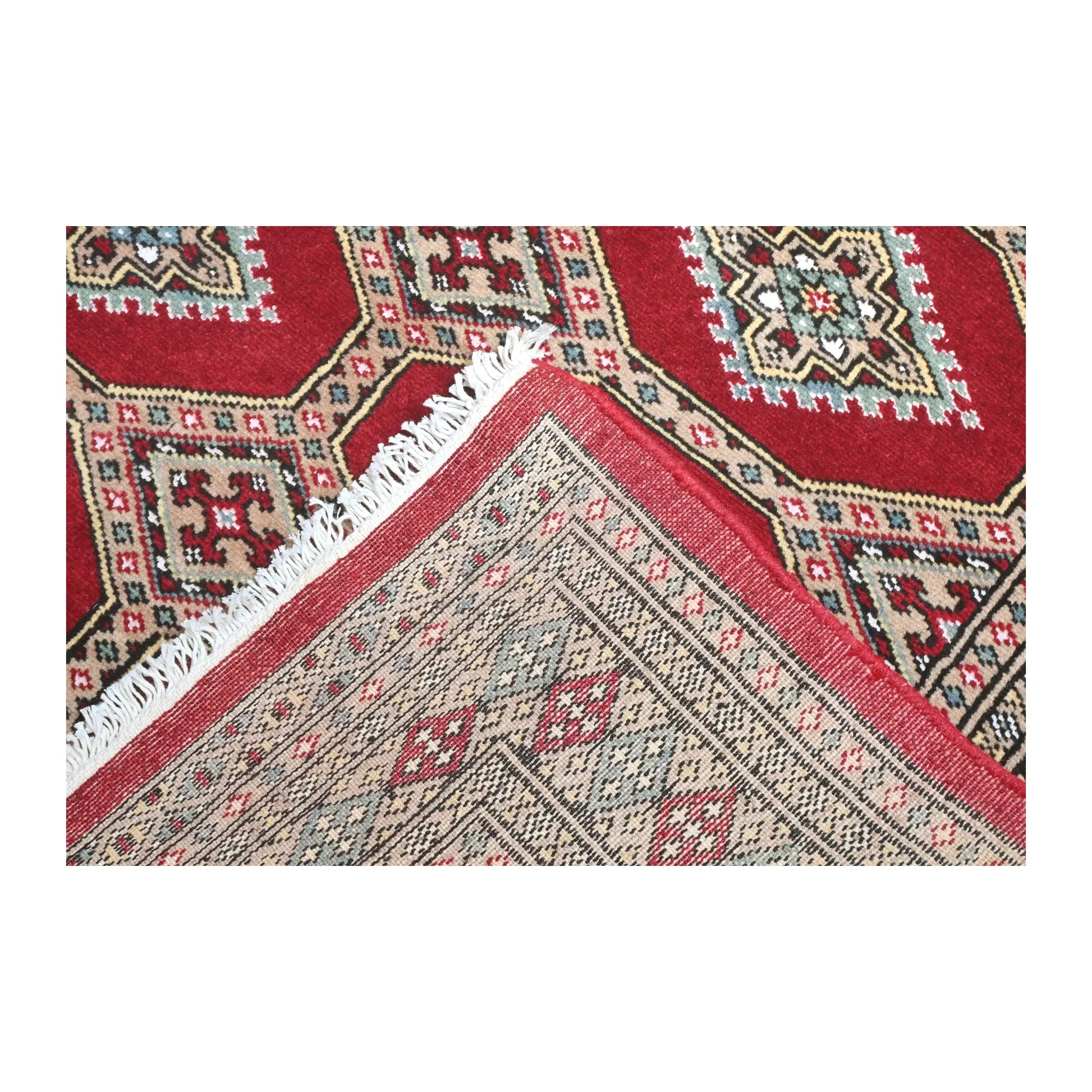 Folded-corner detail of Jaldar rug showing the patterned field, reverse weave and visible fringe