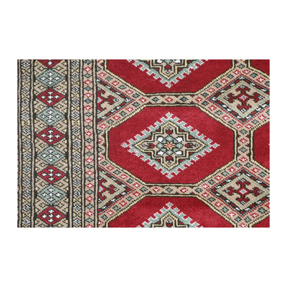Close-up of Jaldar rug showing an angular gul within a red octagonal panel and the layered side border
