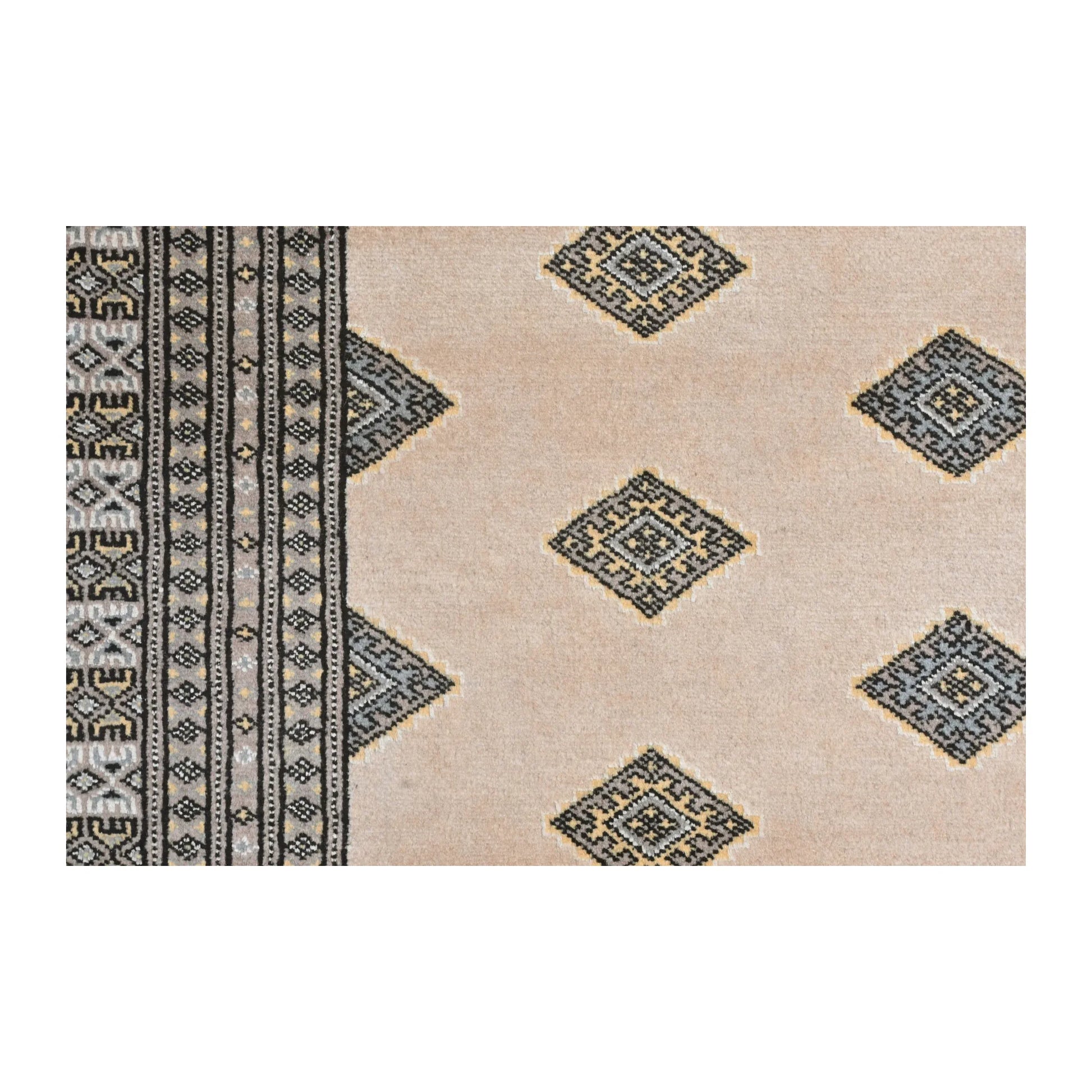 Close-up of Jaldar Silk Touch rug showing angular diamond guls across the beige field and the layered side border