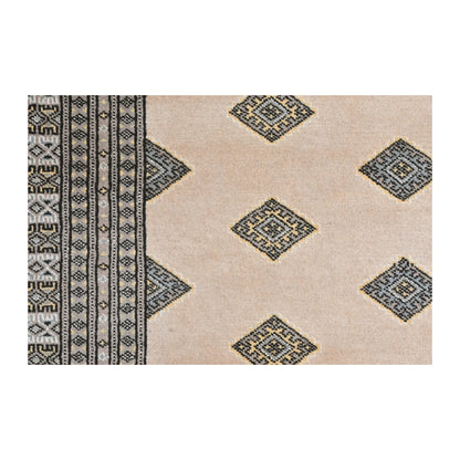Close-up of Jaldar Silk Touch rug showing angular diamond guls across the beige field and the layered side border