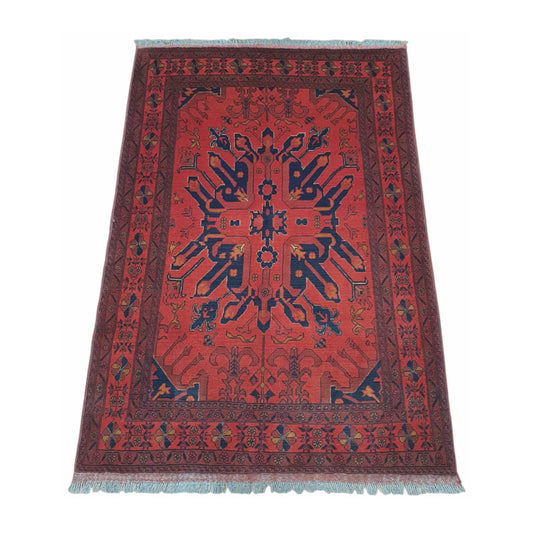 Angled full view of red and navy Khal Mohammadi wool rug showing the symmetrical geometric design and border