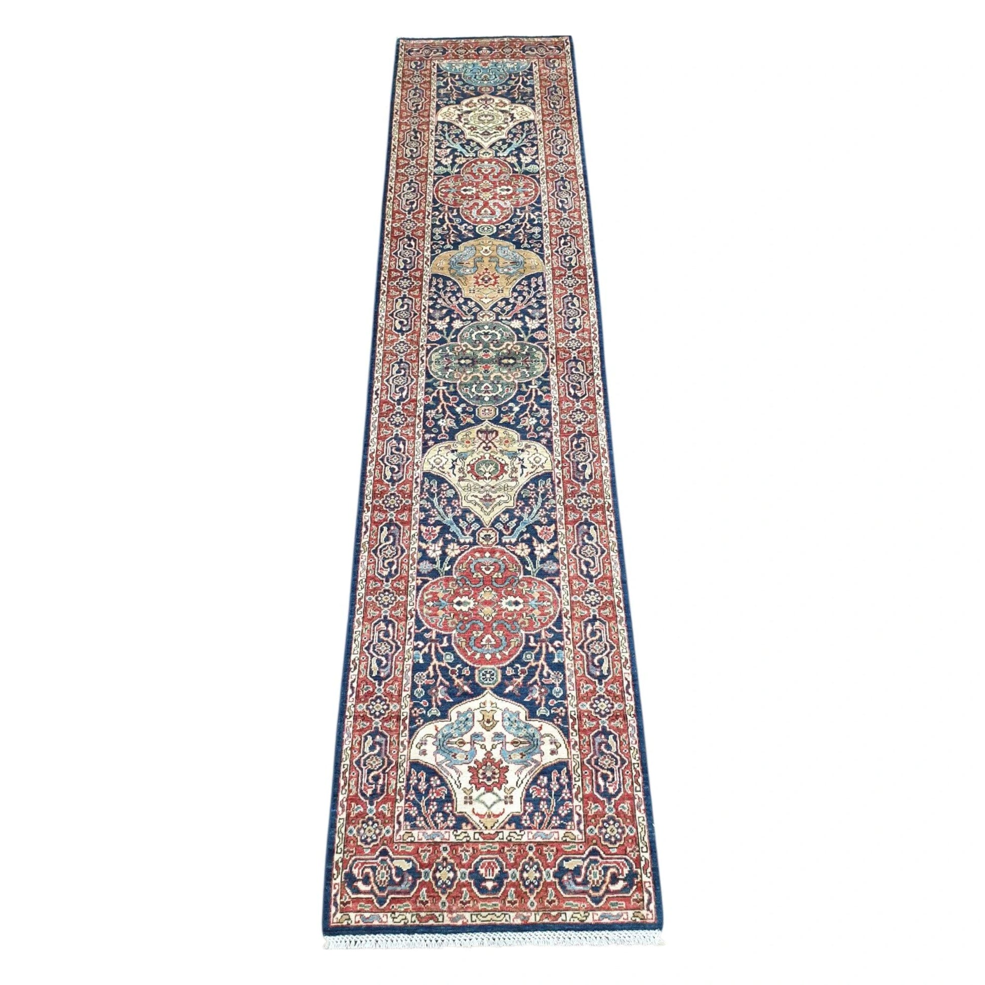 Khurjeen hand-knotted wool runner rug 352 x 81 cm shown in full view with red and navy geometric medallion design