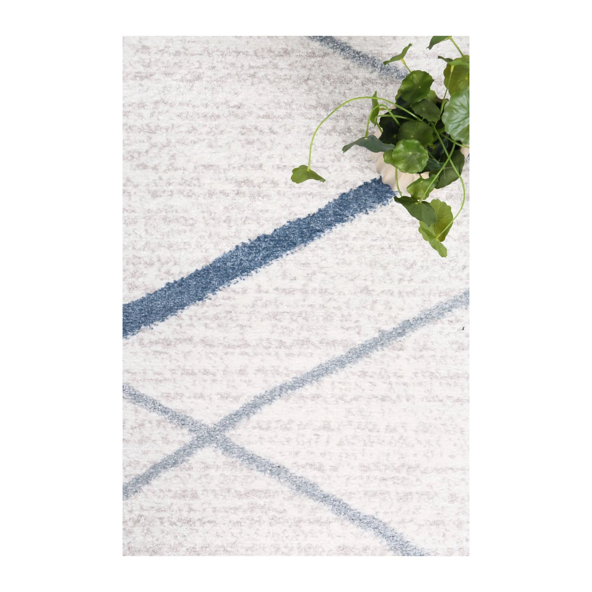 Styled close-up of Kimberley 2 Blue Lattice rug showing white polypropylene pile and blue lattice pattern, 230 x 160 cm