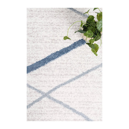 Styled close-up of Kimberley 2 Blue Lattice rug showing white polypropylene pile and blue lattice pattern, 230 x 160 cm