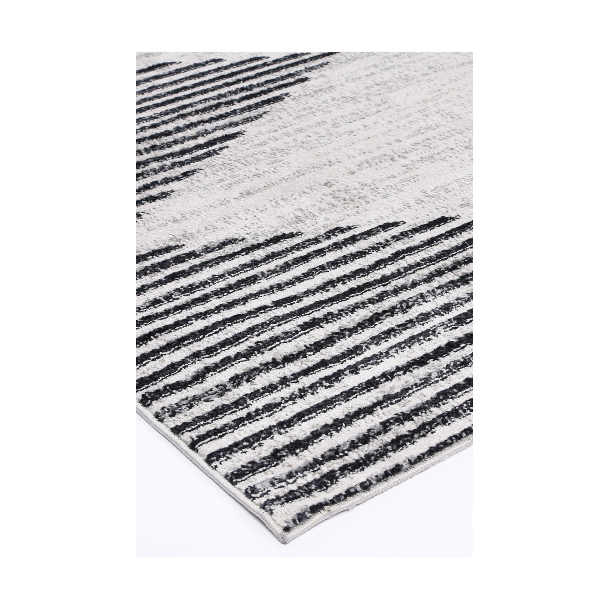 Corner detail of Kimberley 3 Diamond Charcoal rug showing bound edge, charcoal white pattern and textured surface, 230 x 160 cm