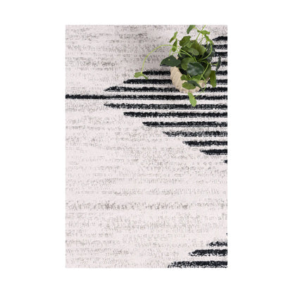Styled close-up of Kimberley 3 Diamond Charcoal rug showing white field, charcoal diamond lines and textured pile, 230 x 160 cm