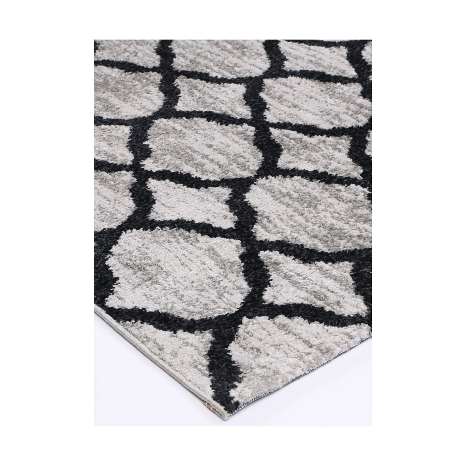 Corner detail of Kimberley 5 Repeat Charcoal rug showing bound edge, textured pile and modern lattice pattern, 230 x 160 cm