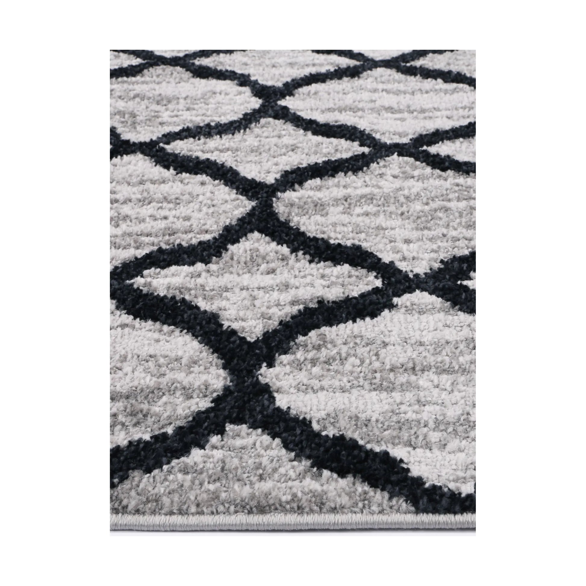 Edge detail of Kimberley 5 Repeat Charcoal rug showing heatset polypropylene pile, grey surface and charcoal pattern, 230 x 160 cm