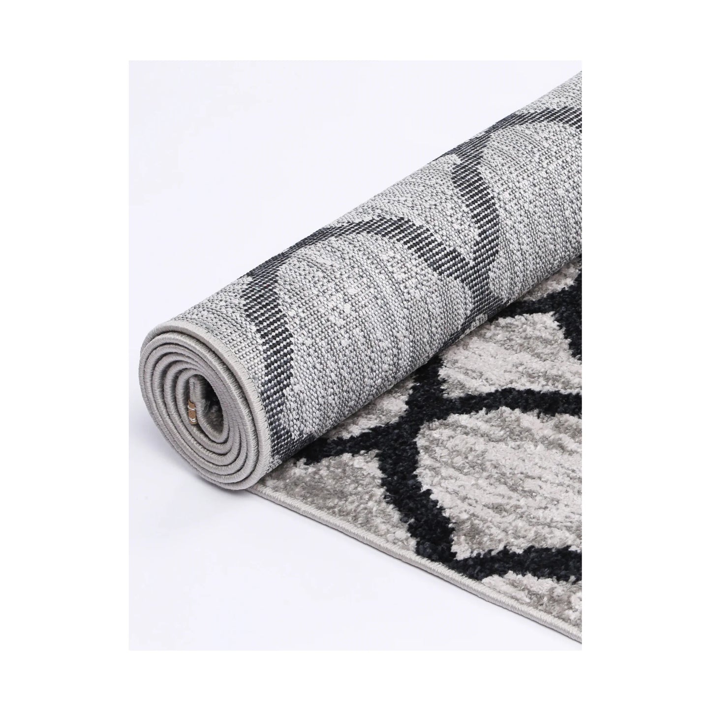 Rolled edge detail of Kimberley 5 Repeat Charcoal rug showing backing, binding and patterned heatset polypropylene pile, 230 x 160 cm