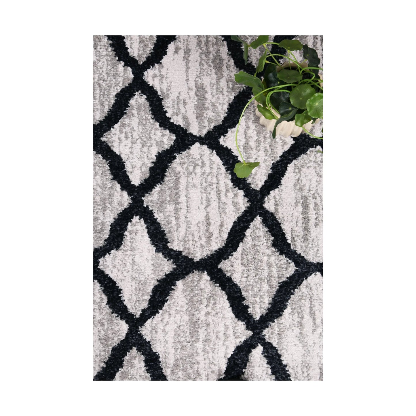 Styled close-up of Kimberley 5 Repeat Charcoal rug showing textured pile and repeating charcoal lattice pattern, 230 x 160 cm