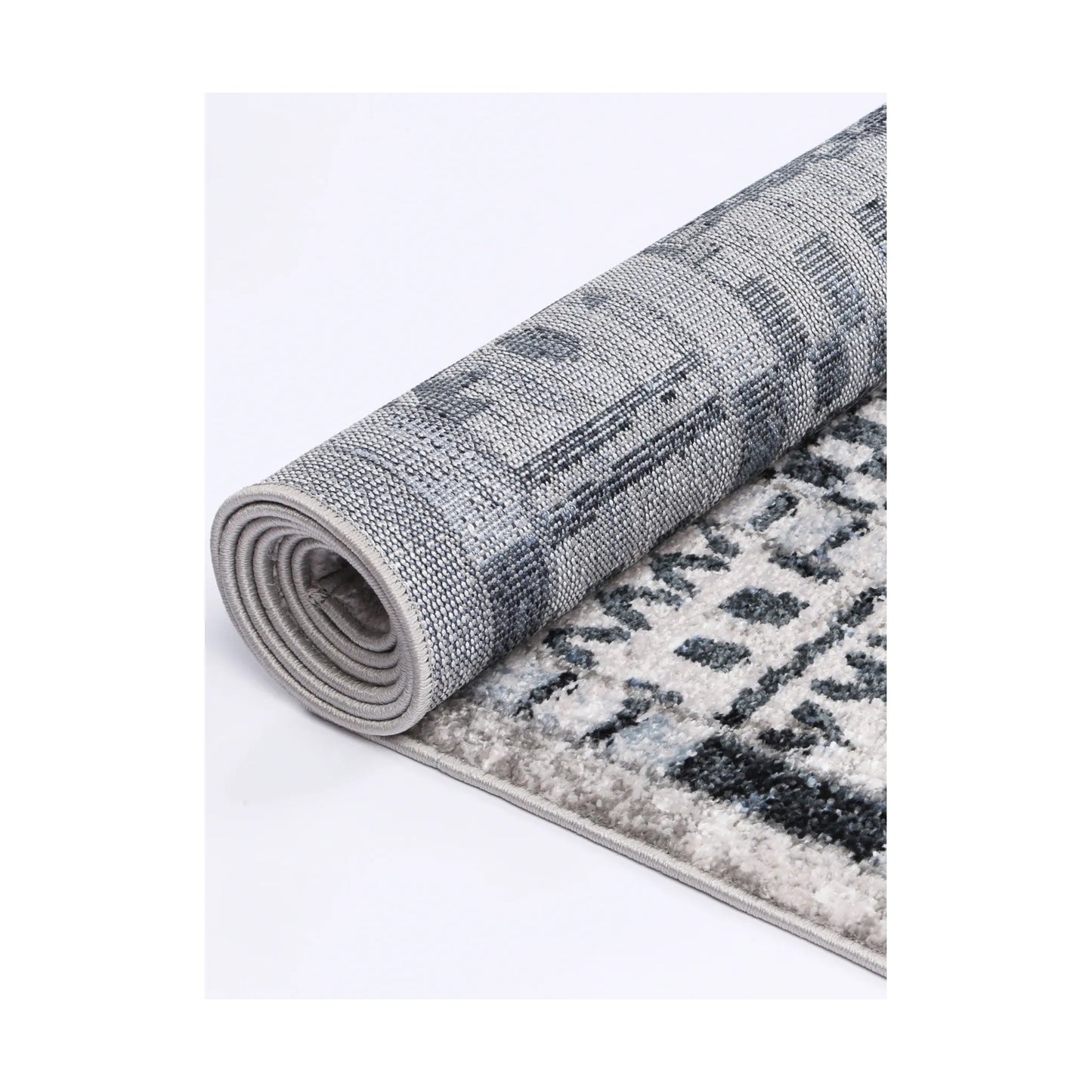 Rolled edge detail of Kimberley 7 Aztec Blue rug showing backing, binding and patterned heatset polypropylene pile, 230 x 160 cm