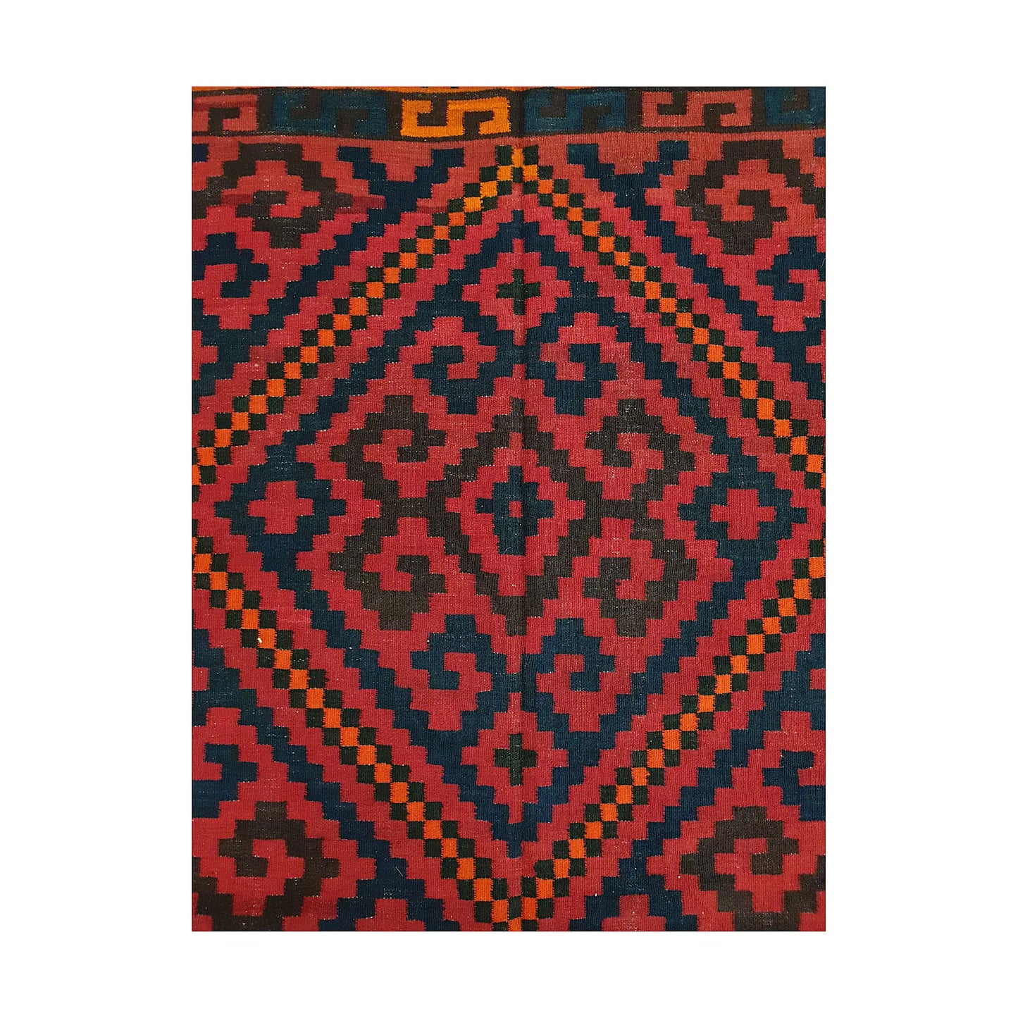 Close-up of Mamina Kilim wool rug showing red geometric medallion pattern with navy, charcoal and orange details