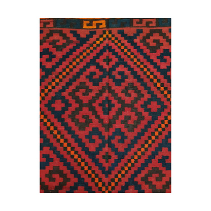 Close-up of Mamina Kilim wool rug showing red geometric medallion pattern with navy, charcoal and orange details