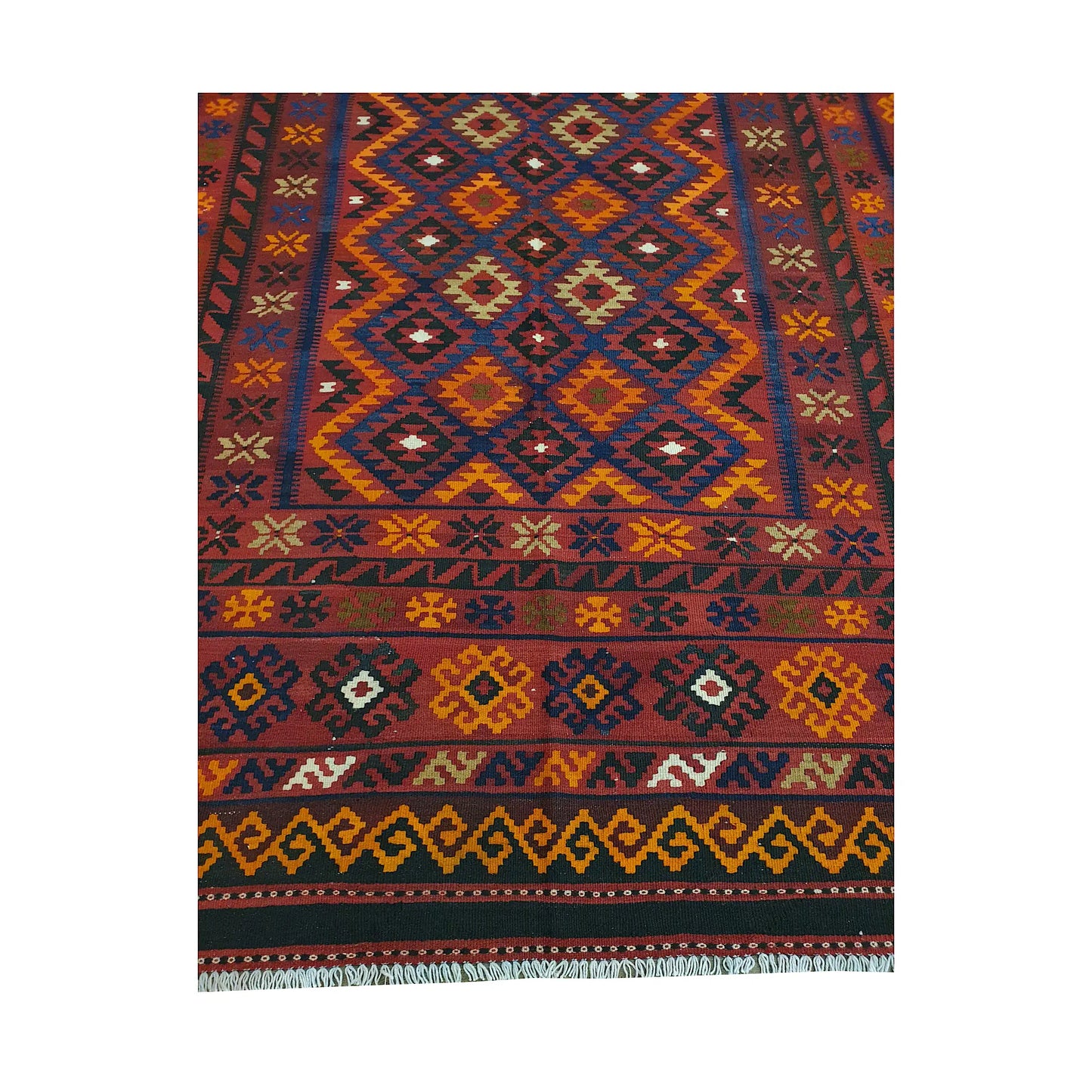 Close detail of Mamina Kilim wool rug showing diamond lattice field, yellow border accents and tribal geometric motifs