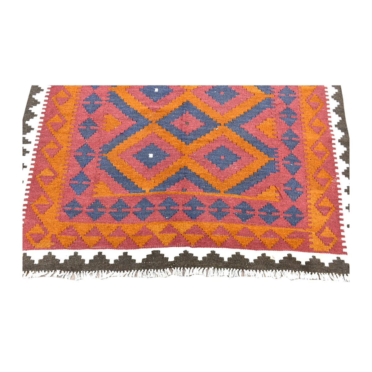 Fringe-end detail of Mamina kilim showing blue angular motifs, orange border patterning and the ivory and dark brown outer border