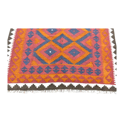 Fringe-end detail of Mamina kilim showing blue angular motifs, orange border patterning and the ivory and dark brown outer border