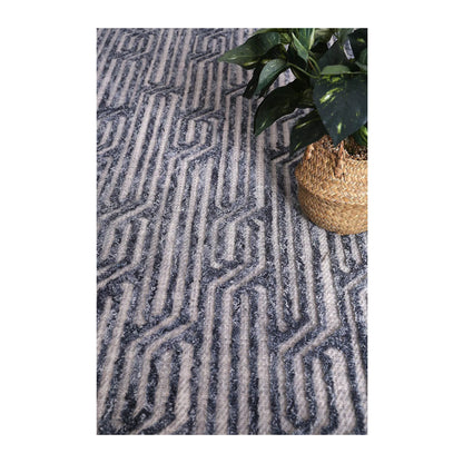 Lifestyle view of Marbella Almeria blue-grey wool rug with charcoal geometric pattern, 230 x 160 cm