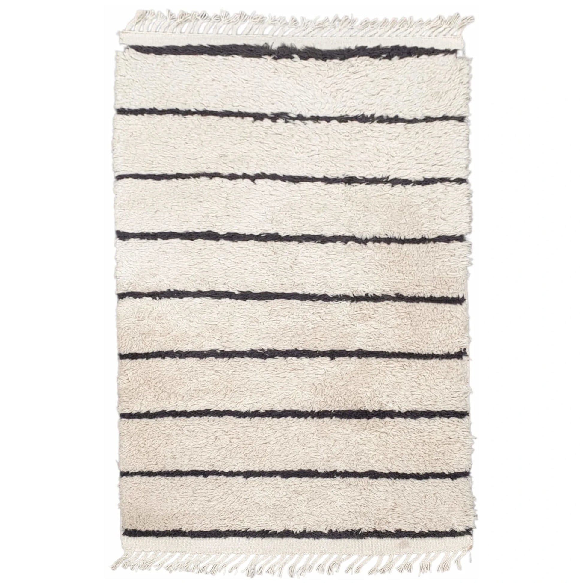Full view of Moroccan Design hand-knotted wool rug with cream field, black horizontal stripes and fringe ends, 165 x 90 cm