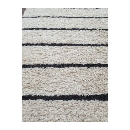Detail of Moroccan Design hand-knotted wool rug showing textured cream wool pile and irregular black stripe pattern, 165 x 90 cm