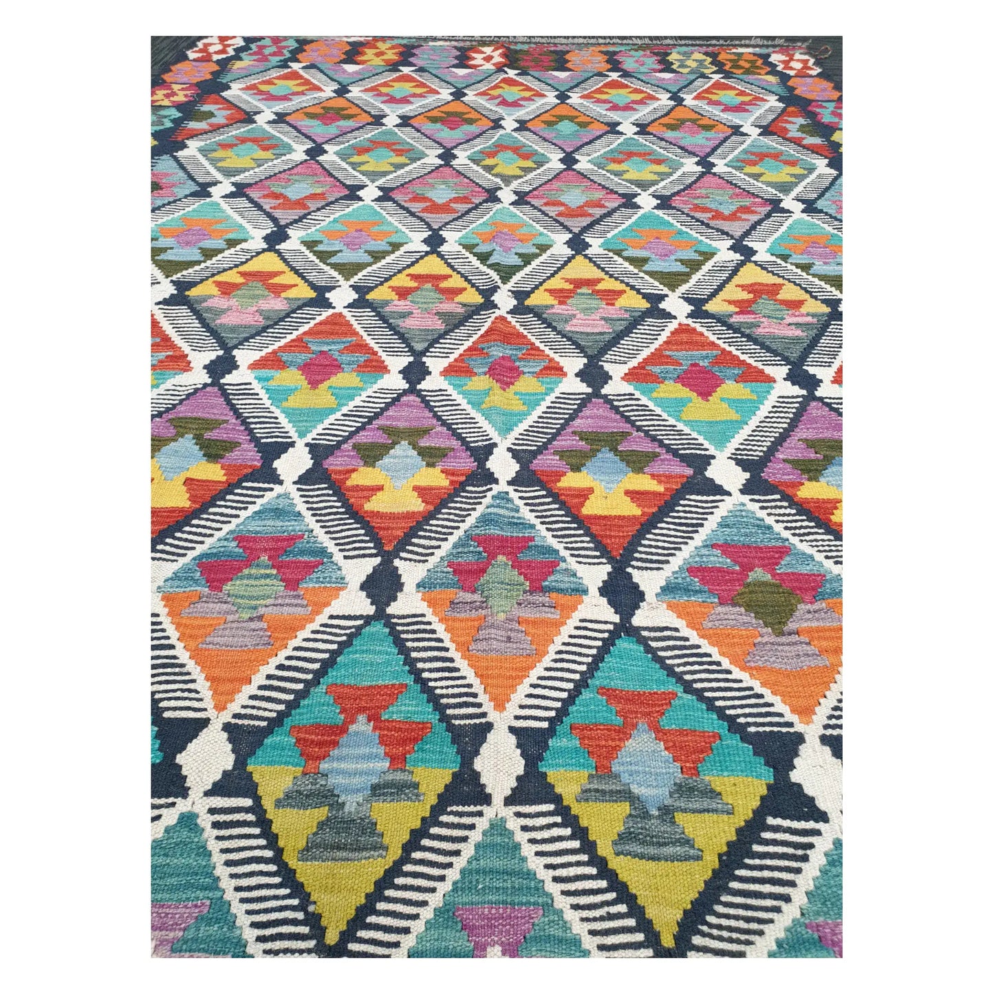 Close-up of Chobi Kilim rug with repeating stepped diamonds in blue, rust, saffron, teal, and ivory, 248 x 172 cm