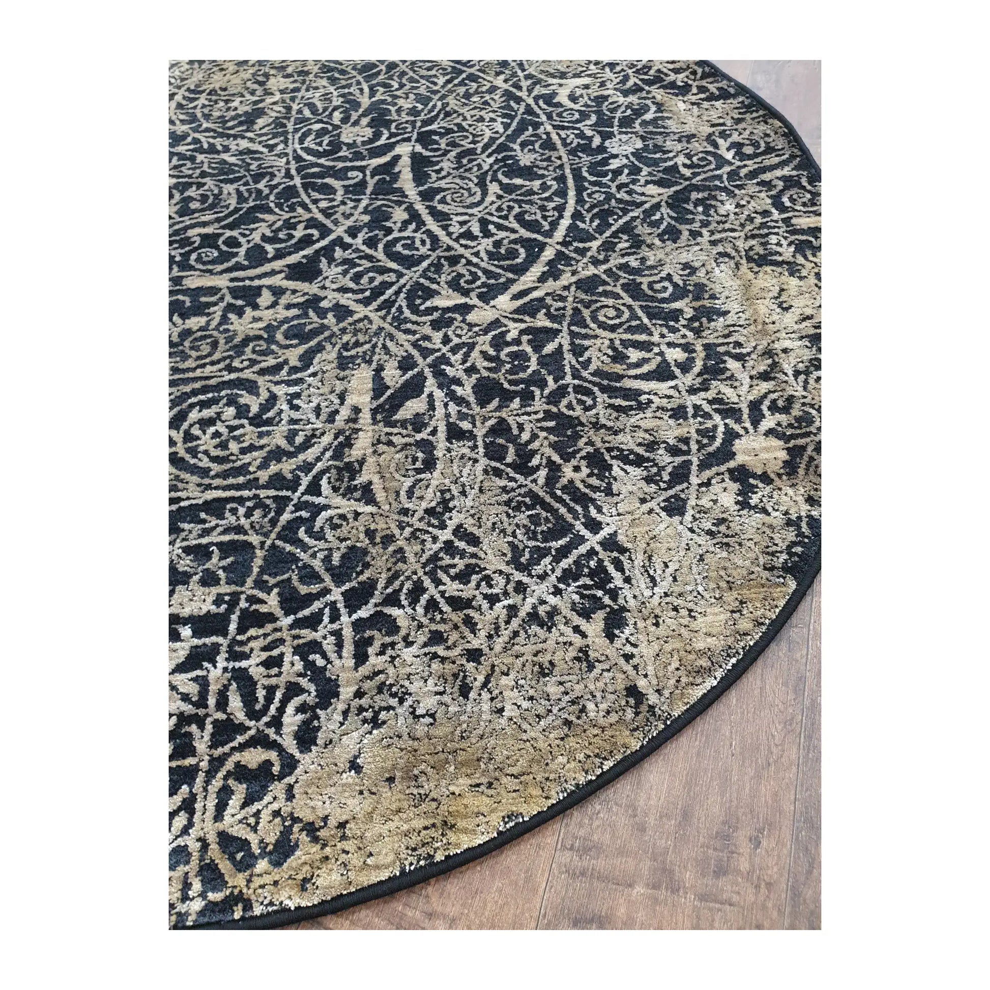 Angled detail of navy and beige round rug showing scroll pattern and edge finish, 160 cm