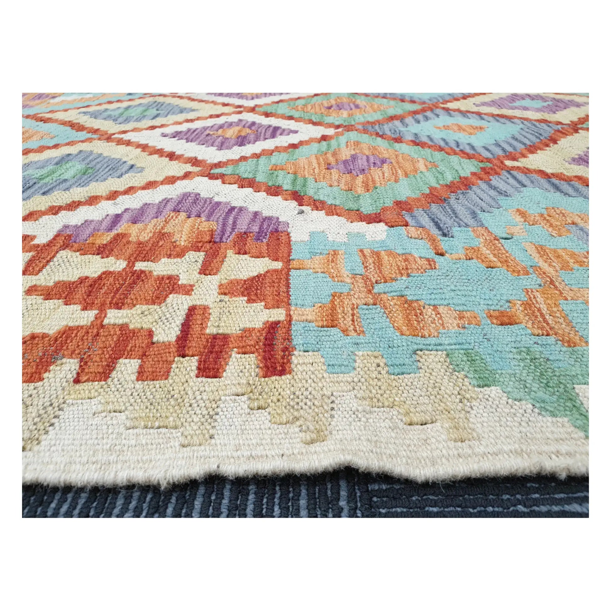 Low-angle close-up of Afghan Chobi Kilim showing wool flatweave texture and multicolour geometric pattern, 133 x 100 cm