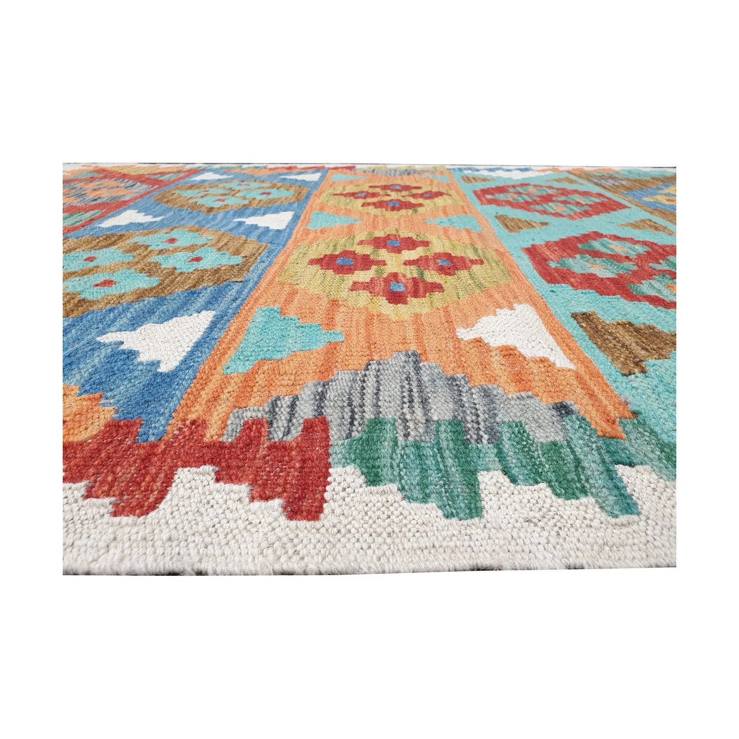 Low-angle detail of Afghan Chobi kilim showing flatwoven texture and stepped motifs along the ivory edge