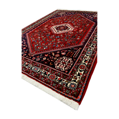 Angled full view of Persian Abadeh hand-knotted wool rug showing the full design, border and central medallion