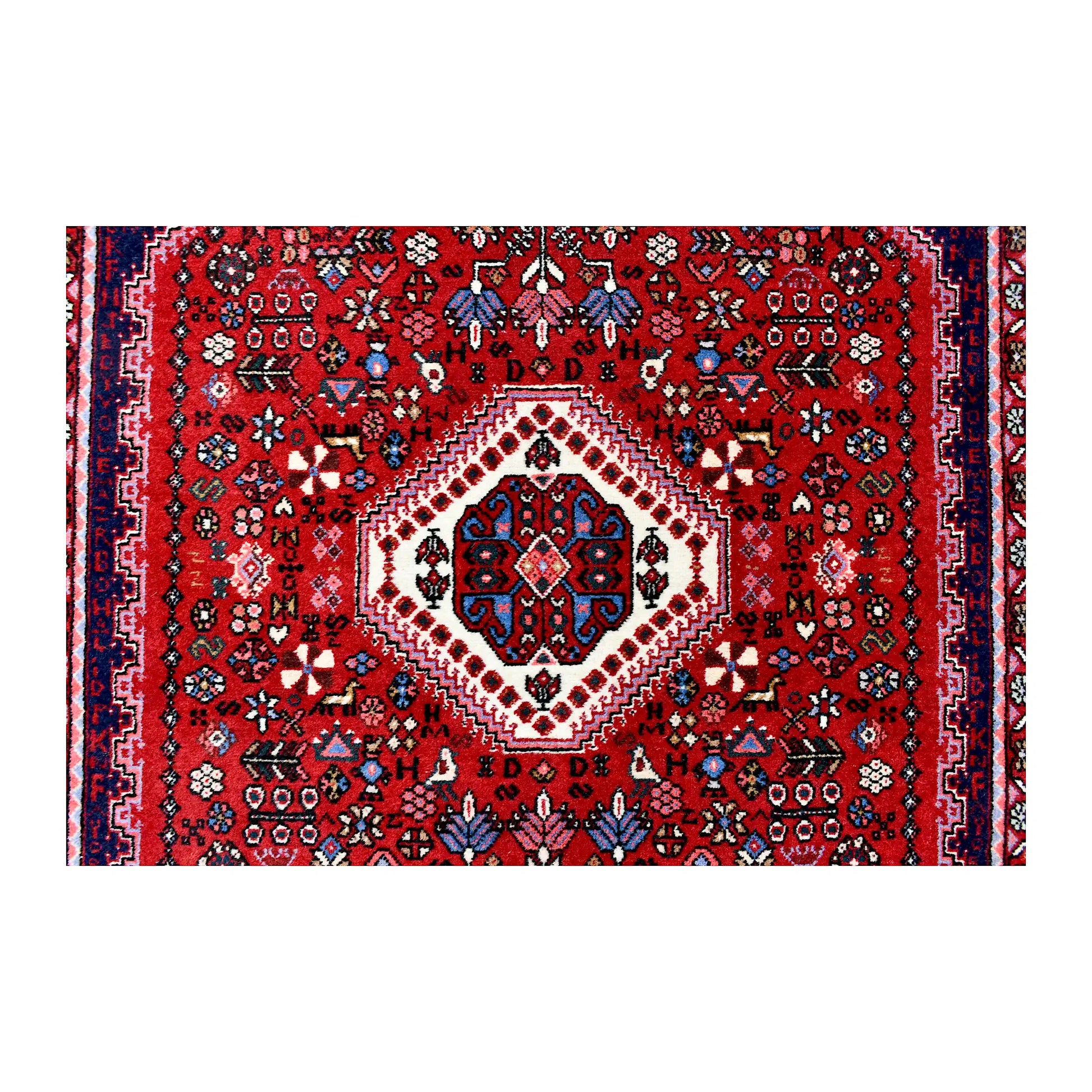 Central medallion detail of Persian Abadeh wool rug showing ivory and navy geometric motifs on a red field