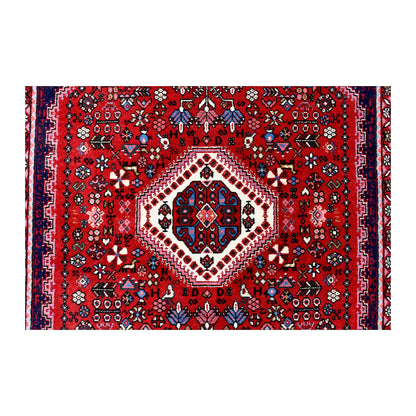 Central medallion detail of Persian Abadeh wool rug showing ivory and navy geometric motifs on a red field