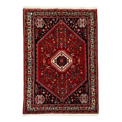 Straightened full view of Persian Abadeh hand-knotted wool rug with red field, bold central medallion and navy corner sections, 150 x 108 cm