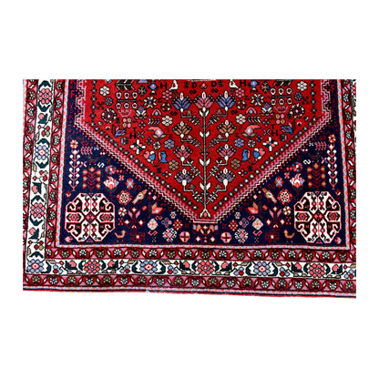 Lower field and border detail of Persian Abadeh hand-knotted wool rug showing red field, navy border panels and floral patterning
