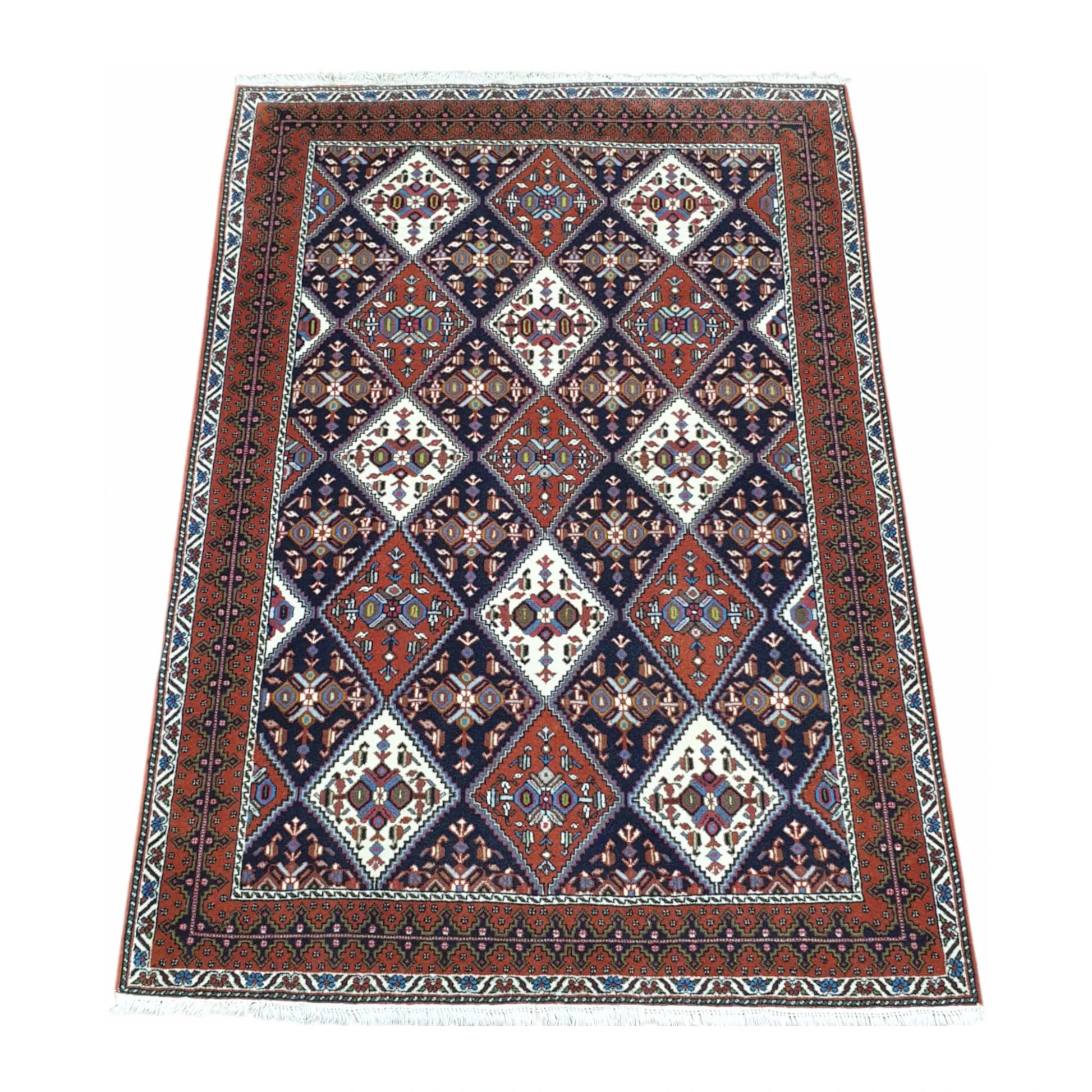 Angled full view of Persian Afshar wool rug 180 x 124 cm with tribal geometric pattern and framed border