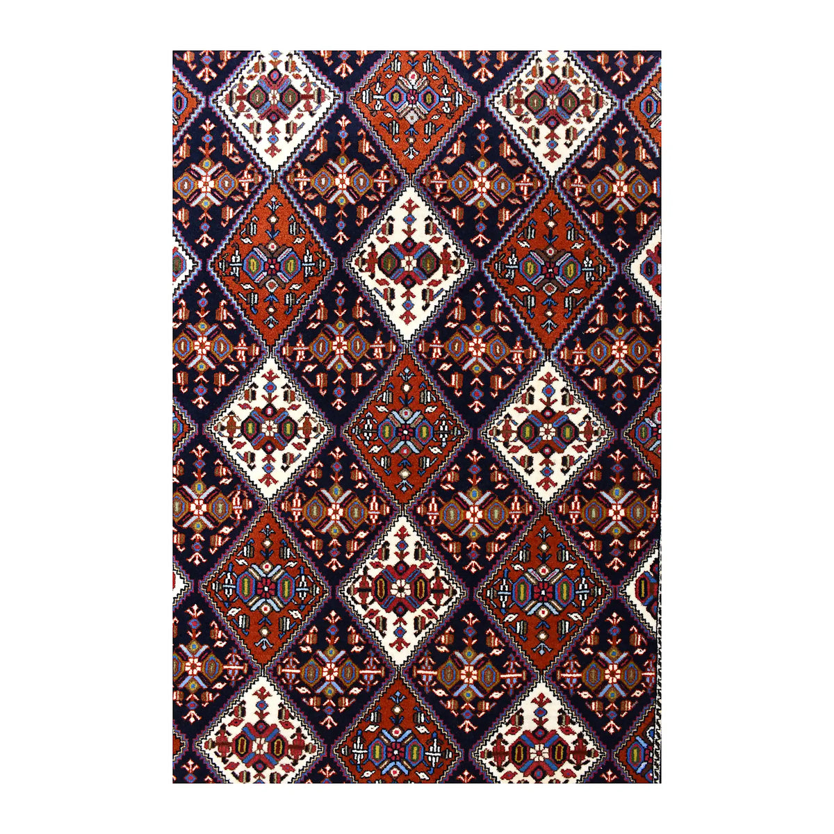 Field detail of Persian Afshar rug showing a repeating diamond lattice in dark navy, rust red and ivory