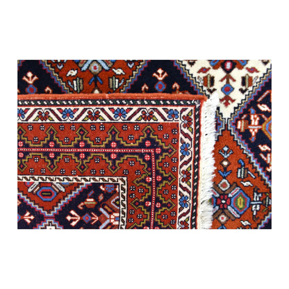 Folded-corner detail of Persian Afshar rug showing the reverse weave, front pattern and pale fringe