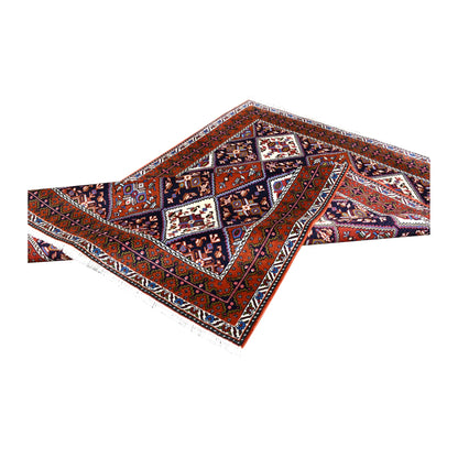 Folded view of Persian Afshar hand-knotted wool rug showing its patterned pile, borders and fringe