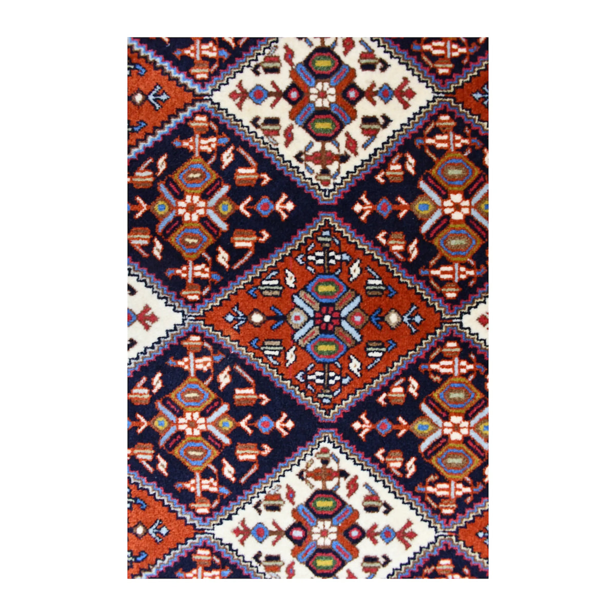 Close-up of Persian Afshar rug showing alternating geometric motifs within the diamond lattice