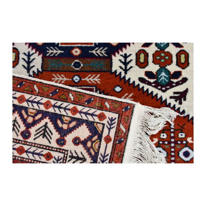 Folded corner of Persian Ardabil rug showing the patterned face, reverse weave and ivory fringe