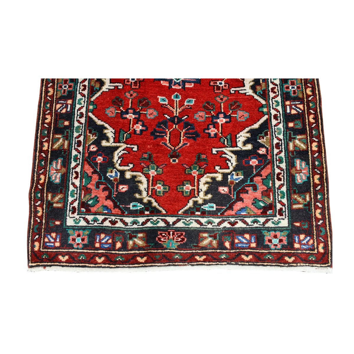 End detail of Persian Hamadan runner showing a floral medallion, branching motifs, layered borders and fringe