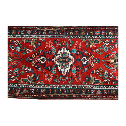 Overhead section of Persian Hamadan runner showing the red medallion field and layered floral borders
