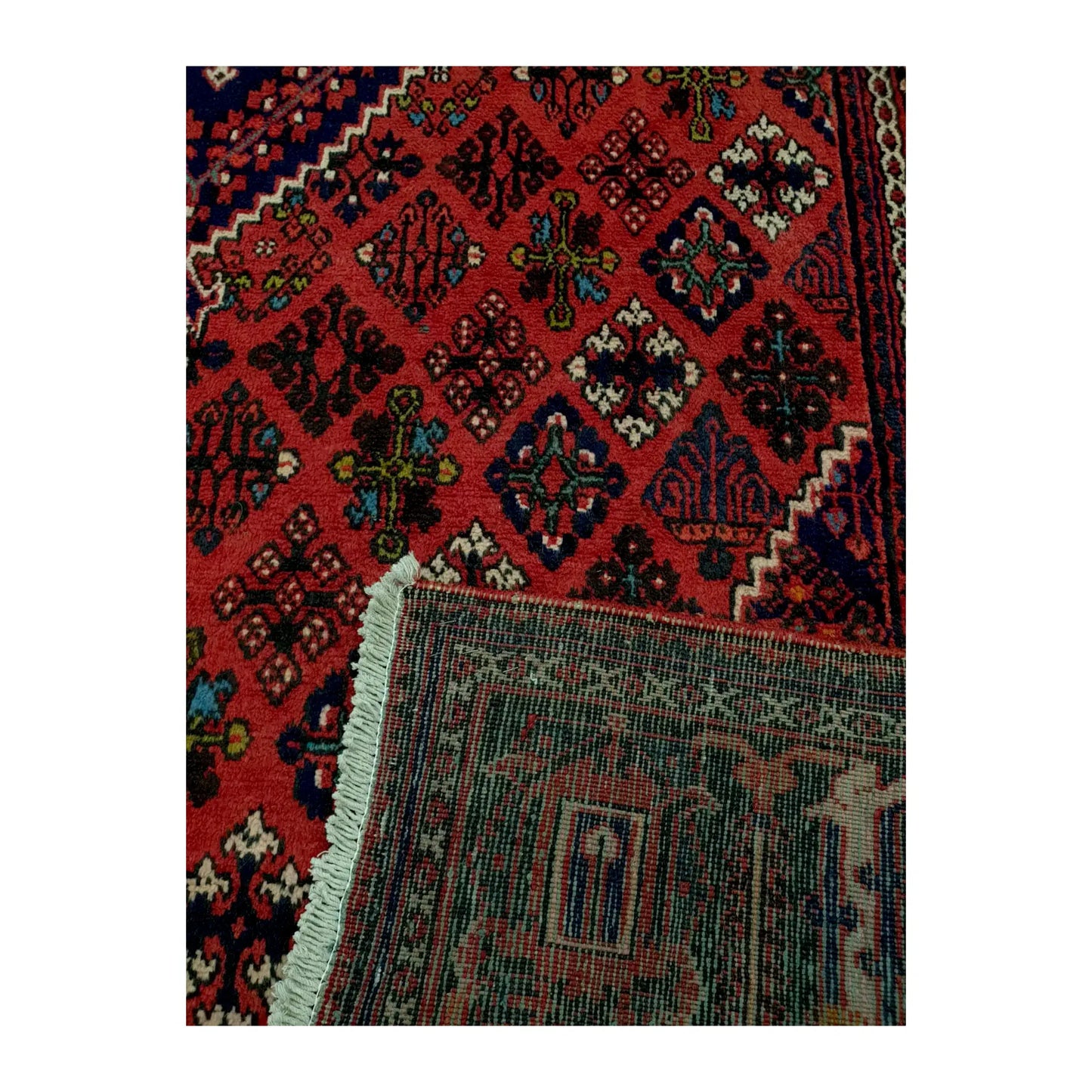 Folded corner of Persian Meimeh wool rug, 300 x 210 cm, showing the patterned pile, reverse weave and cream fringe