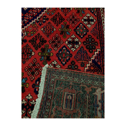Folded corner of Persian Meimeh wool rug, 300 x 210 cm, showing the patterned pile, reverse weave and cream fringe