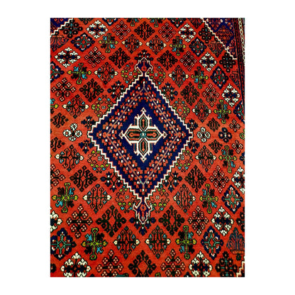 Close view of the stepped navy diamond medallion and multicoloured geometric motifs on the red field