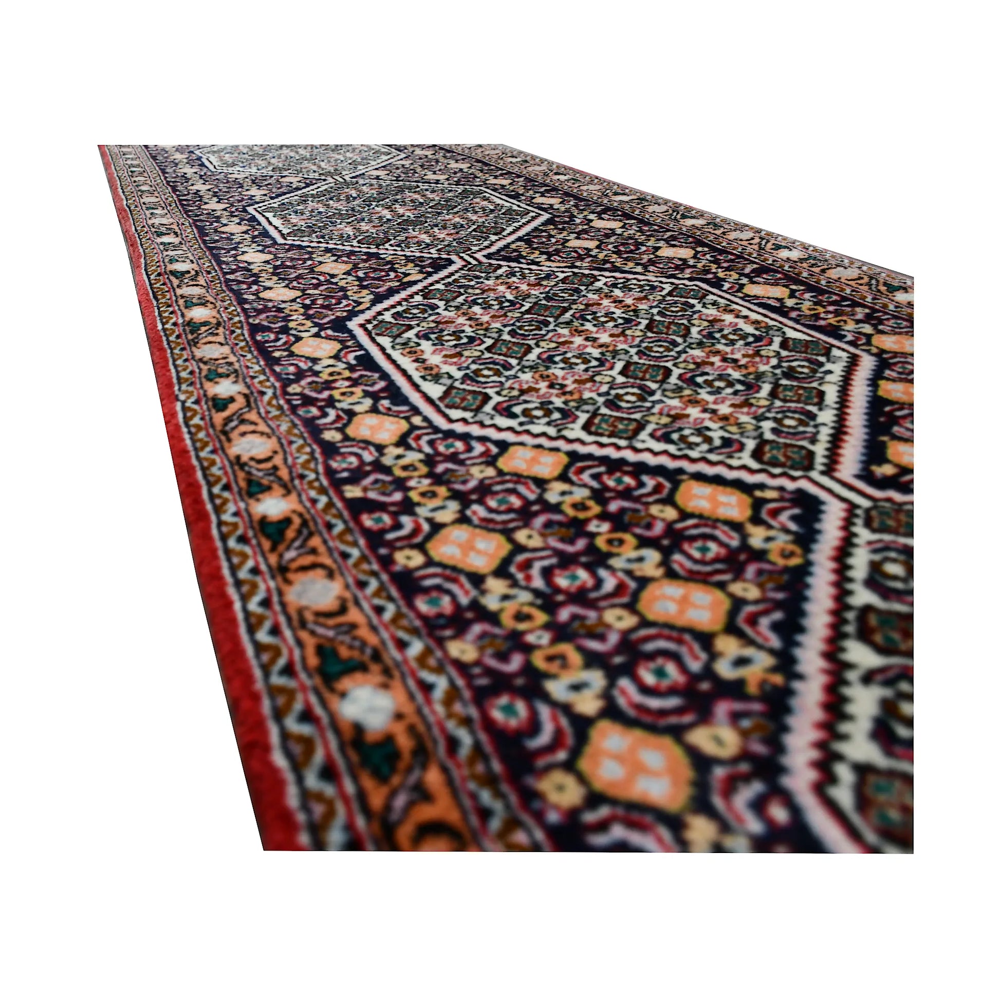 Angled side detail of Persian Senneh runner showing fine floral motifs, indigo ground and narrow red border