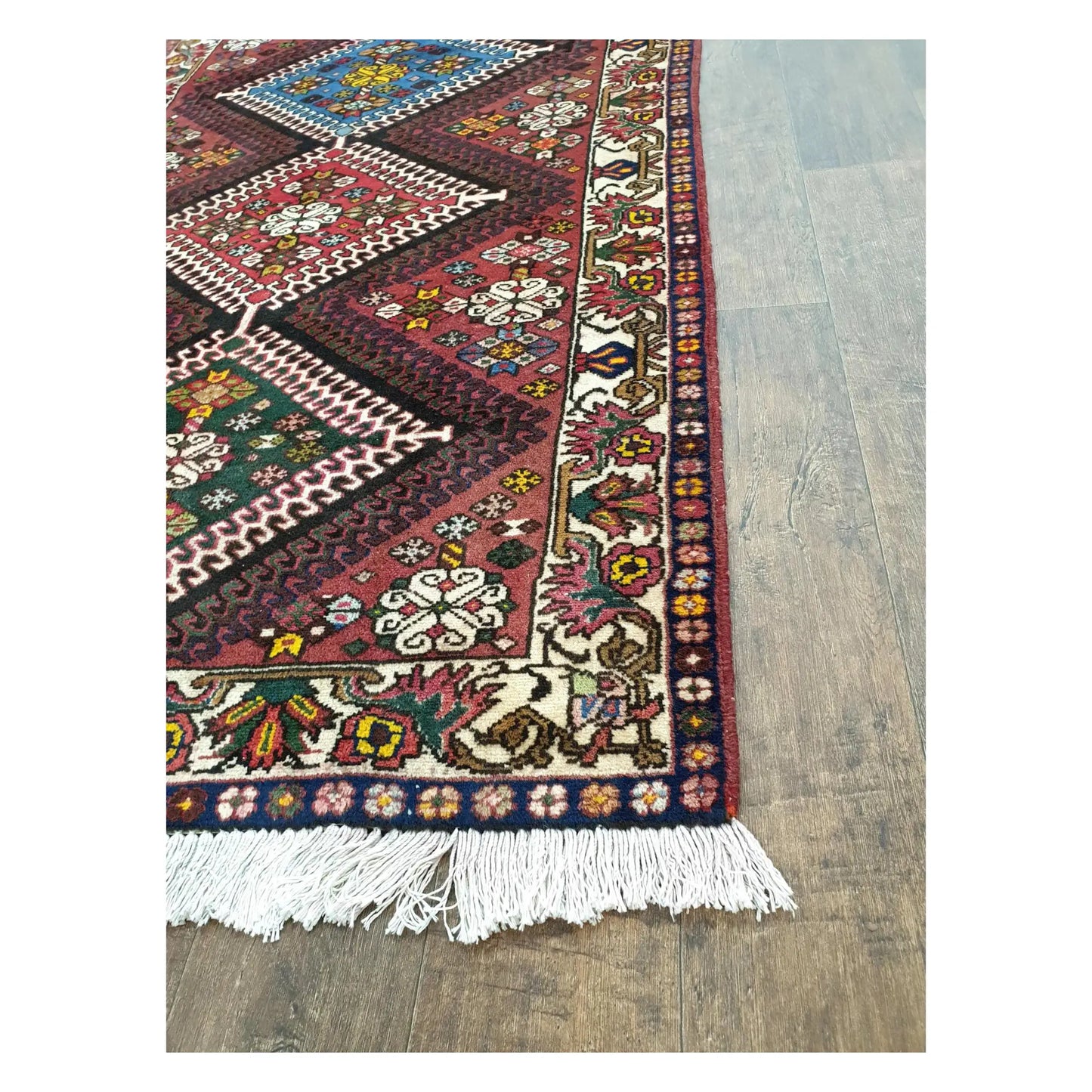 Border and fringe detail of Persian Shiraz wool rug with red and multi-colour pattern